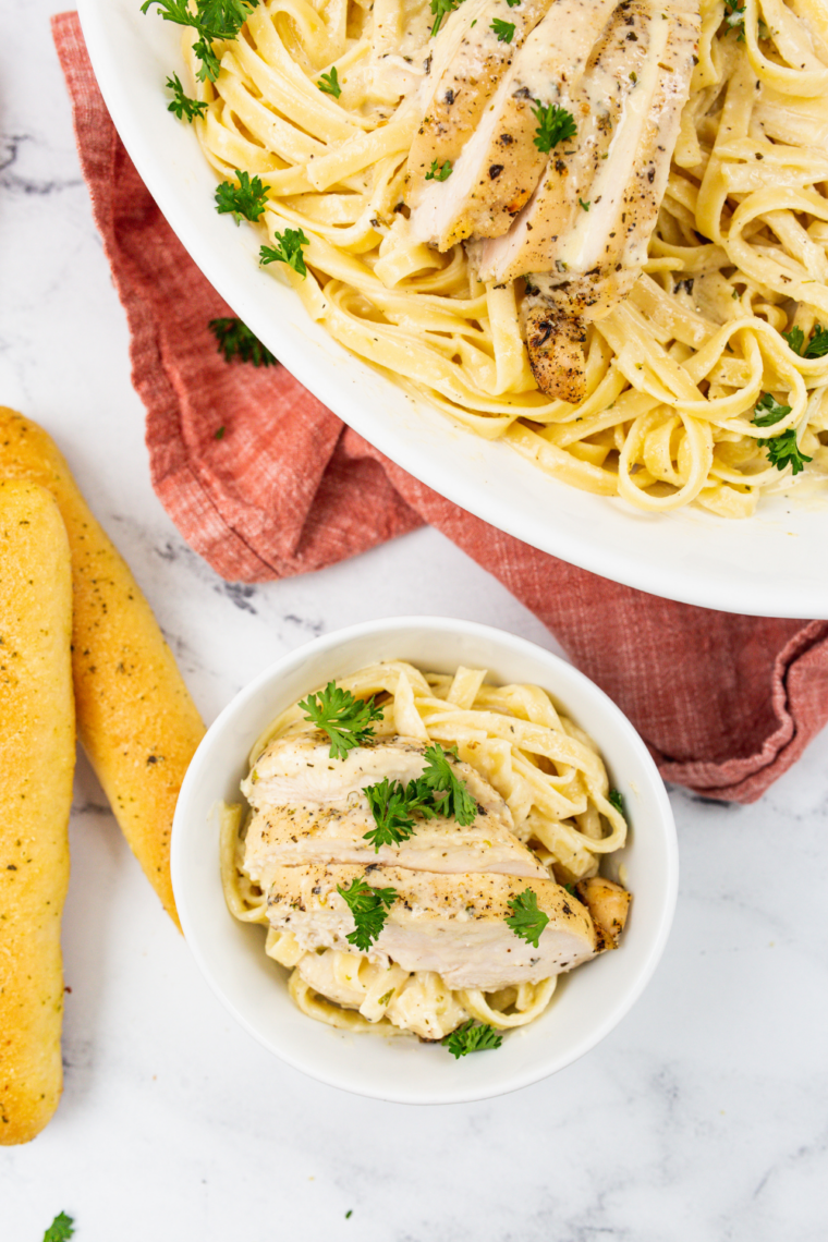 Plate of creamy chicken fettuccine Alfredo with parmesan and parsley