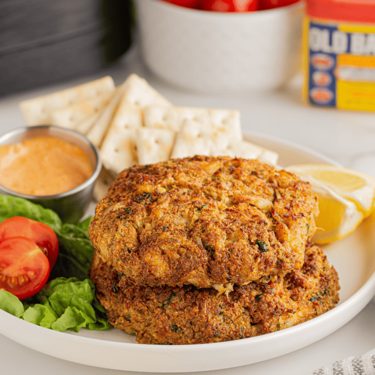 Golden frozen crab cakes cooked in air fryer basket with crispy edges