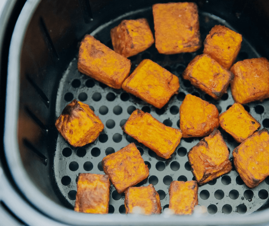 Place seasoned sweet potatoes in the air fryer at 380°F, shaking for even cooking.