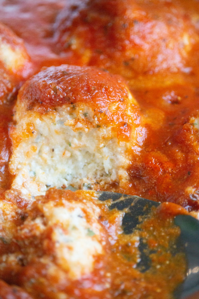 Plate of golden Air Fryer Ricotta Meatballs served with savory pasta sauce.