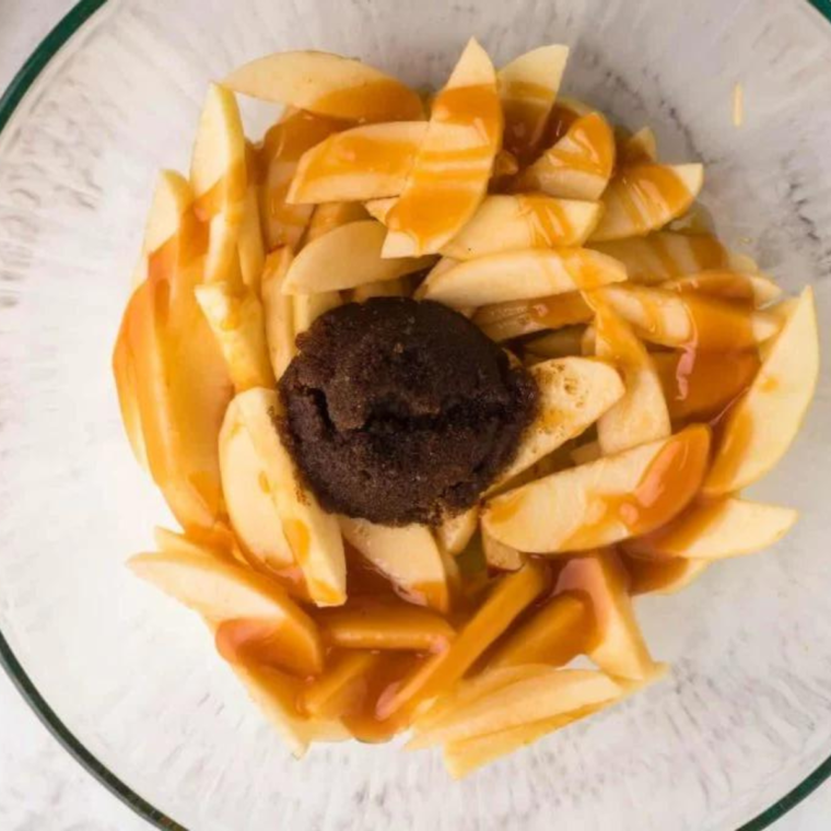 Diced Granny Smith apples tossed with amaretto, cinnamon, and brown sugar in a glass bowl