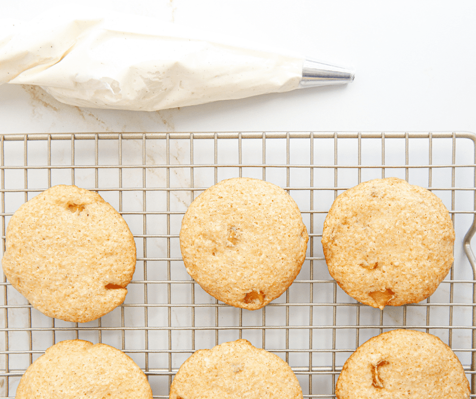 Air-fried apple pie spice cookies cooling on a tray while frosting is being prepared.