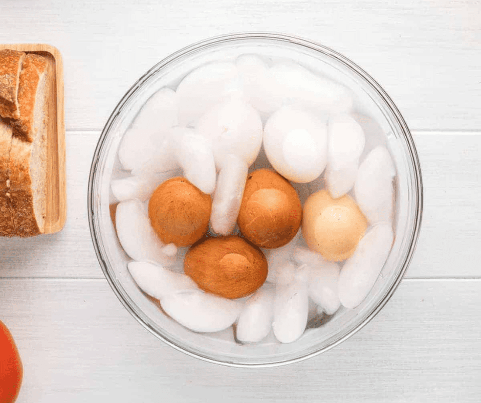 Air fryer eggs transferred to cold water bath after cooking to stop residual heat, cooled for 5 minutes, then peeled easily.