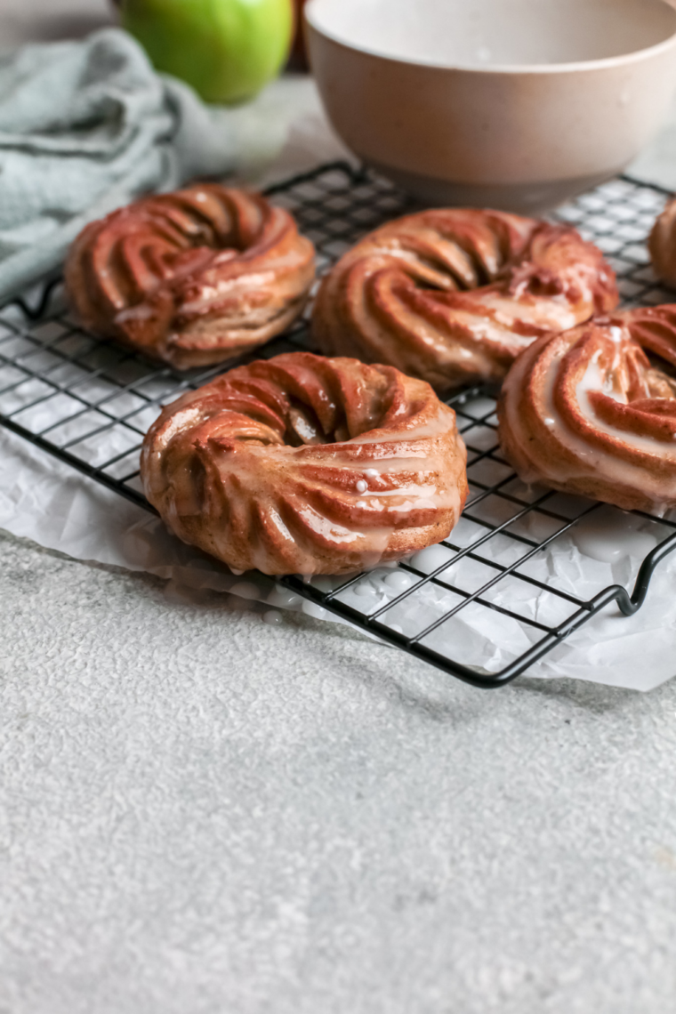 Air fryer French crullers cooling on a wire rack with apple cider glaze setting