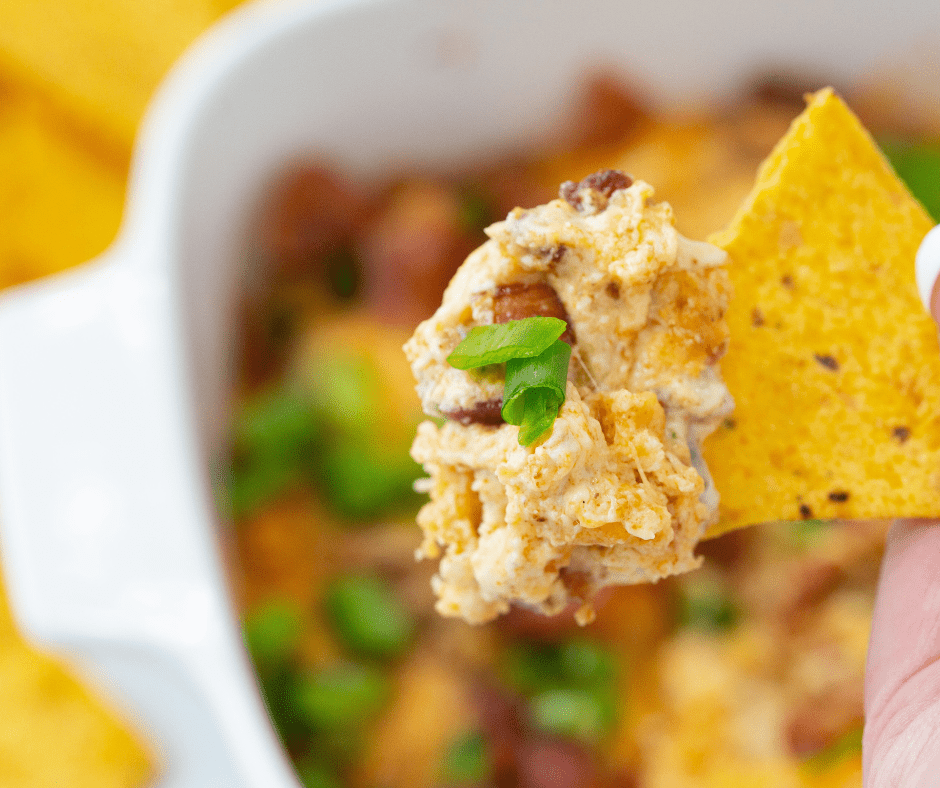 A creamy and cheesy Air Fryer Jalapeno Popper Dip topped with melted cheese and sliced jalapenos, served in a rustic bowl with tortilla chips on the side.
