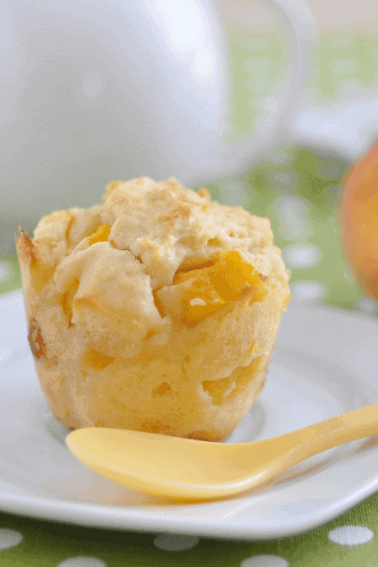 Golden air fryer peach muffins with soft, fluffy centers and juicy peach pieces, freshly baked and ready to enjoy.