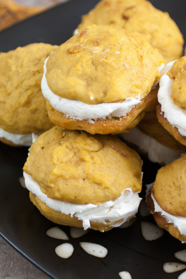 Air Fryer Pumpkin Whoopie Pies with fluffy pumpkin cakes and creamy cream cheese filling served on a dessert plate.