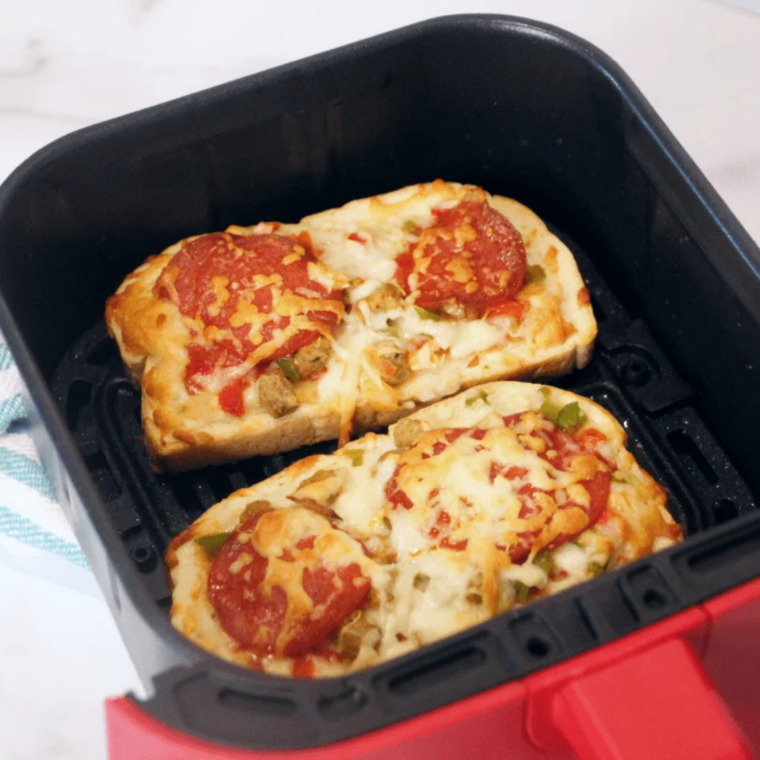 Air fryer set to 350°F cooking pizza melts until cheese is melted and bread edges turn golden brown.