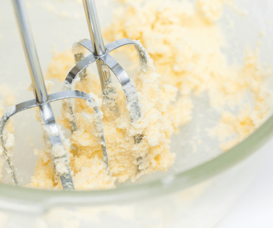 Mixing dry ingredients in one bowl and creaming butter with sugar and extracts in another