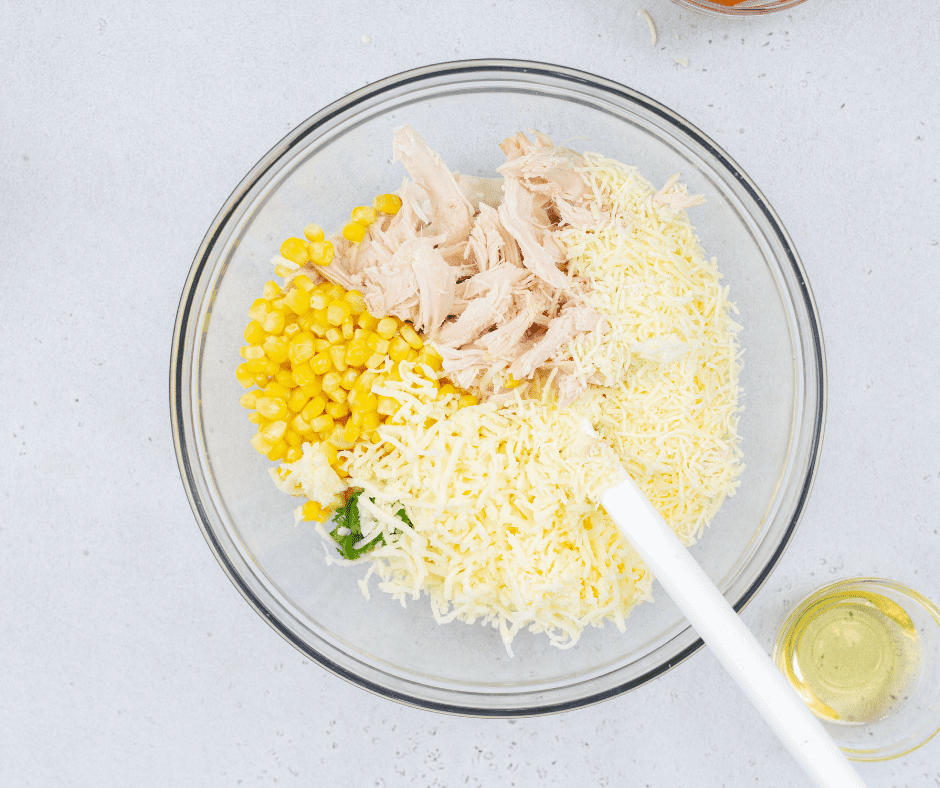 Mixing white beans, chicken, and cheese for Air Fryer White Chicken Chili Dip.