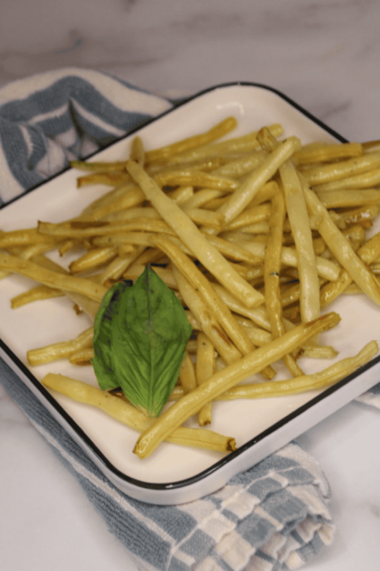 Golden crispy yellow wax beans cooked in an air fryer, seasoned to perfection and ready to eat.