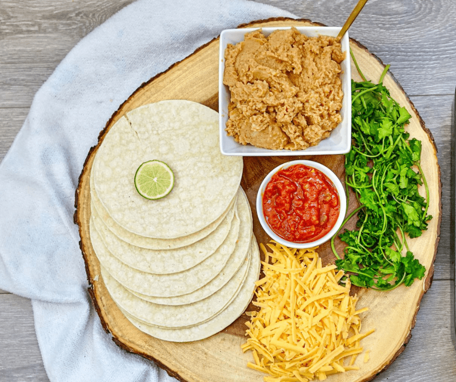 Shredded cheddar cheese, refried beans, and corn tortillas for bean and cheese air fryer taquitos