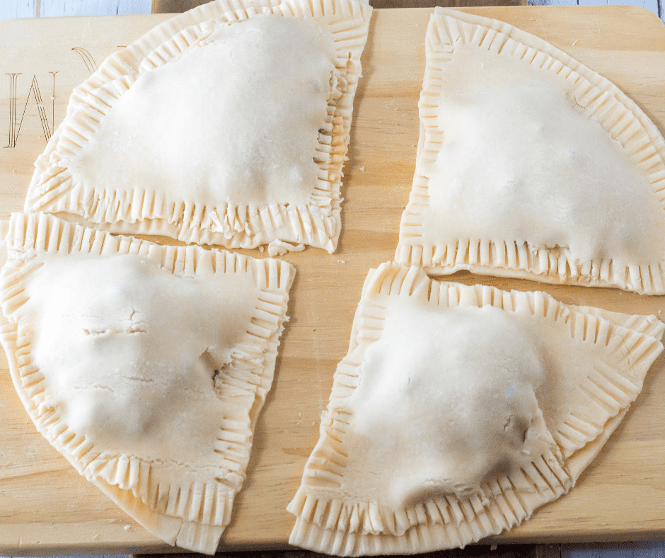 Rolling out pie dough on a floured surface to create a base for the Air Fryer S'mores Hand Pies.