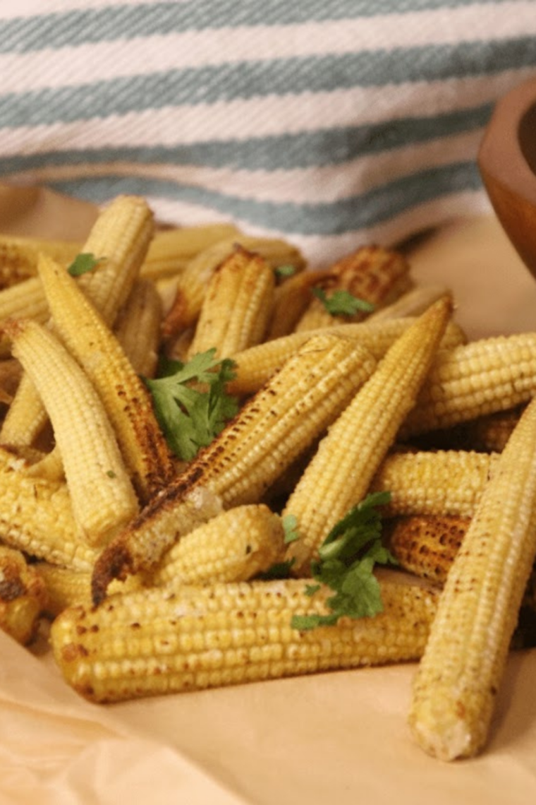 Golden, crispy air fryer baby corn served on a plate, ready to eat.