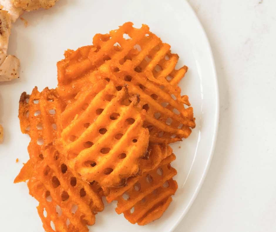 A plate of crispy and golden Air Fryer Frozen Sweet Potato Waffle Fries, served as a tasty snack or side dish.