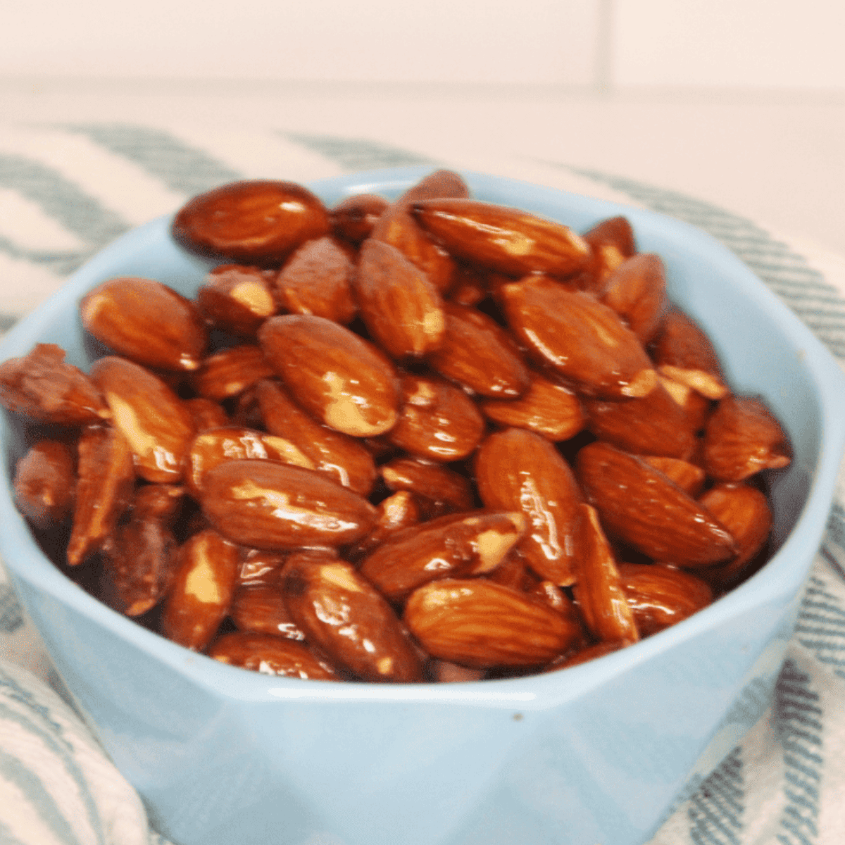 Air Fryer Honey Roasted Almonds coated in honey, sugar, salt, and pepper, toasted to golden perfection in a bowl.