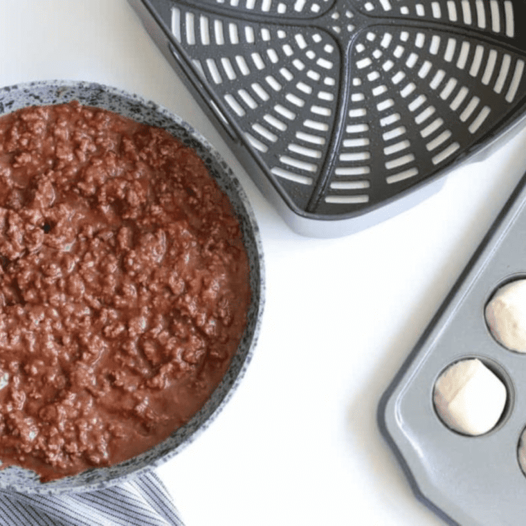 Draining cooked ground beef and adding ketchup, tomato sauce, BBQ sauce, and garlic powder to the mixture for Air Fryer Sloppy Joe Bites.