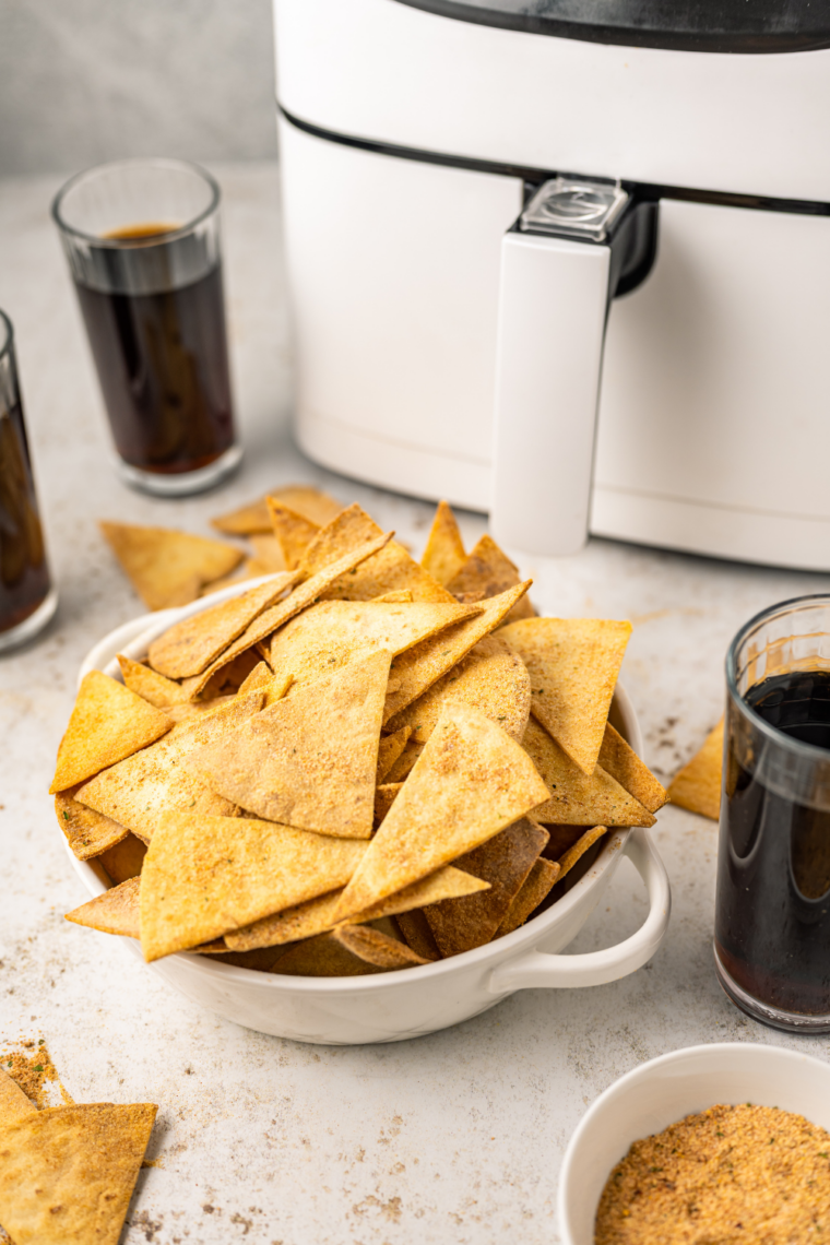 Golden crispy air fryer taco tortilla chips piled in a bowl with salsa