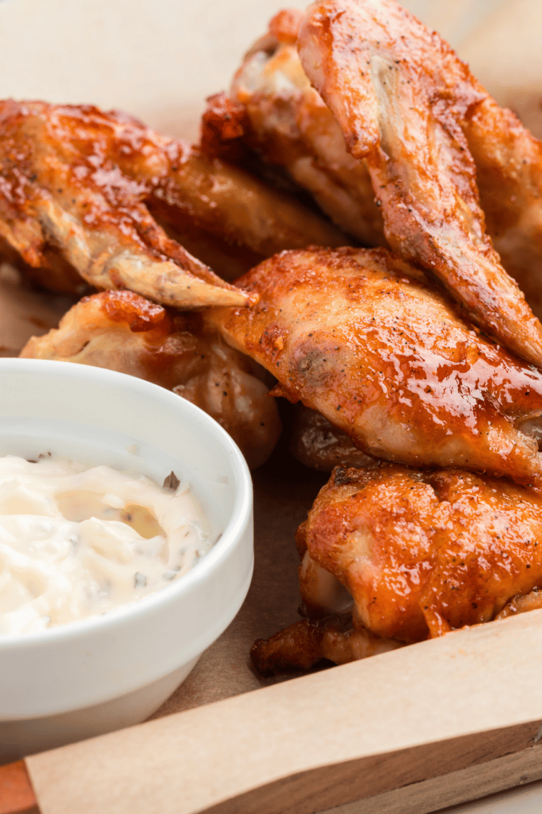 Plate of crispy Wingstop-style mild chicken wings coated in buttery sauce and served hot with dipping sauce.