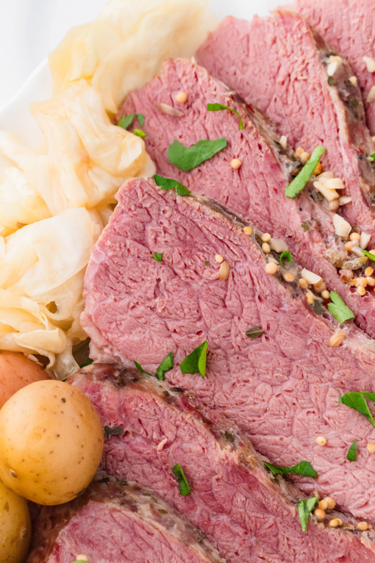 Close-up of air fryer corned beef brisket slices with seasoning and crispy browned exterior on a plate.