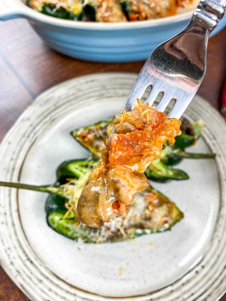 Delicious Air Fryer Stuffed Poblano Peppers filled with ground beef, corn, and cheese, displayed on a white plate, garnished with fresh herbs.