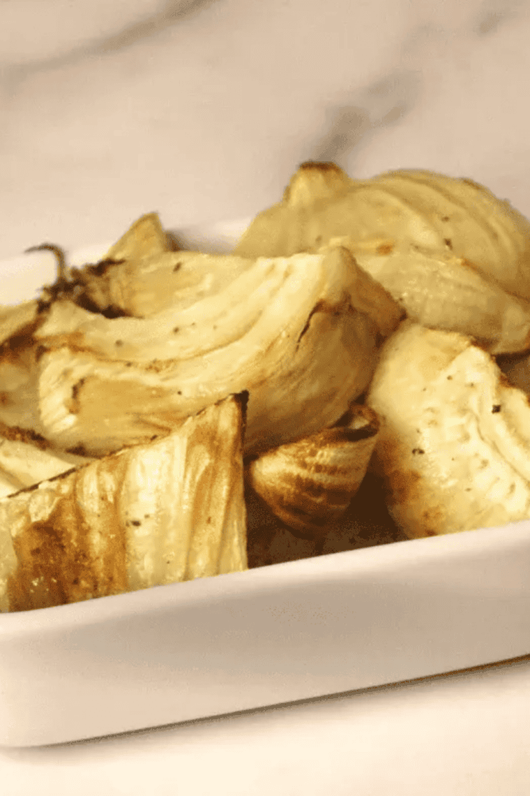Plate of air fryer fennel wedges topped with grated Parmesan and chopped fennel fronds