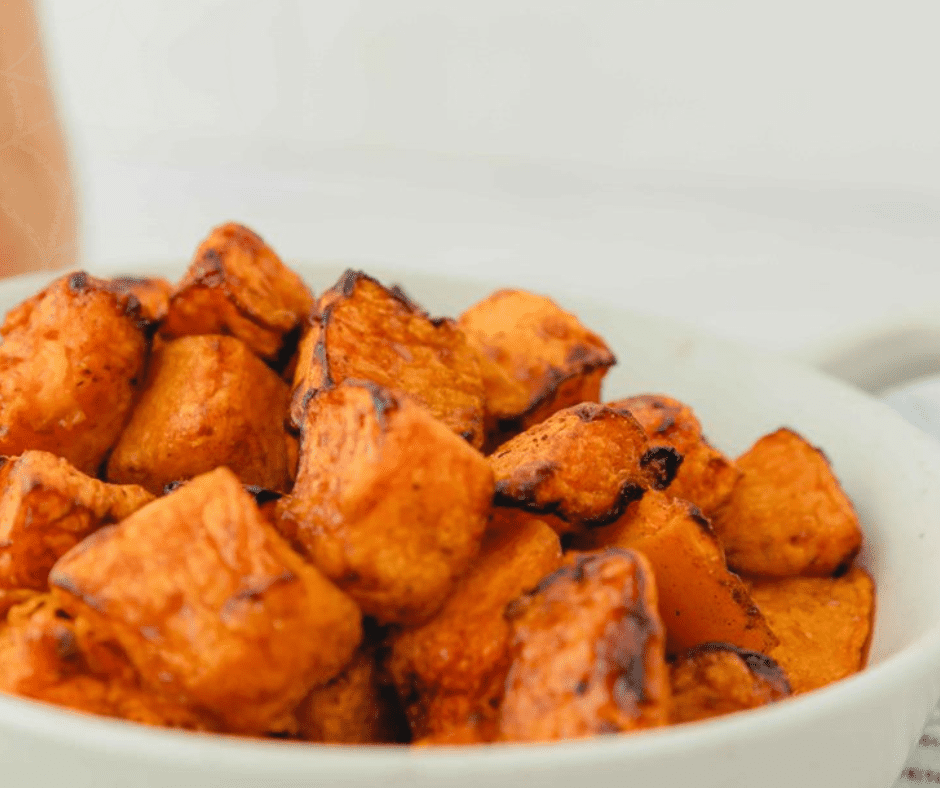 Air fryer basket filled with golden, crispy sweet potato home fries, perfectly cooked for a delicious side dish.