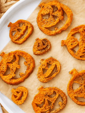 Sweet potato jack-o-lanterns with carved faces on a white platter