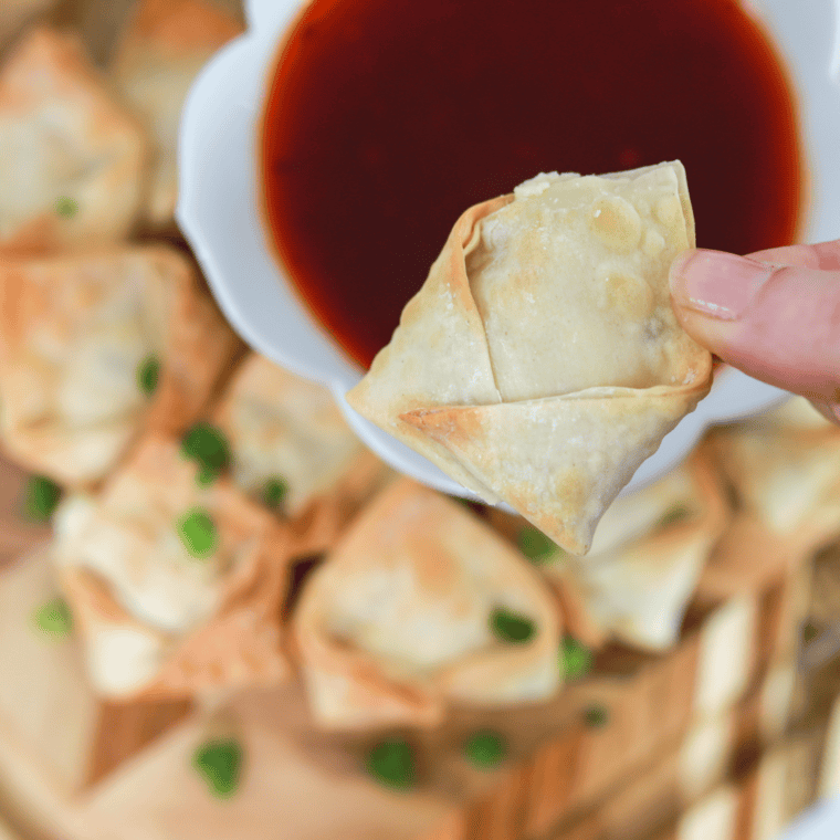 Golden brown Air Fryer Cream Cheese Rangoon served on a plate with a crispy, crunchy exterior and creamy filling inside.