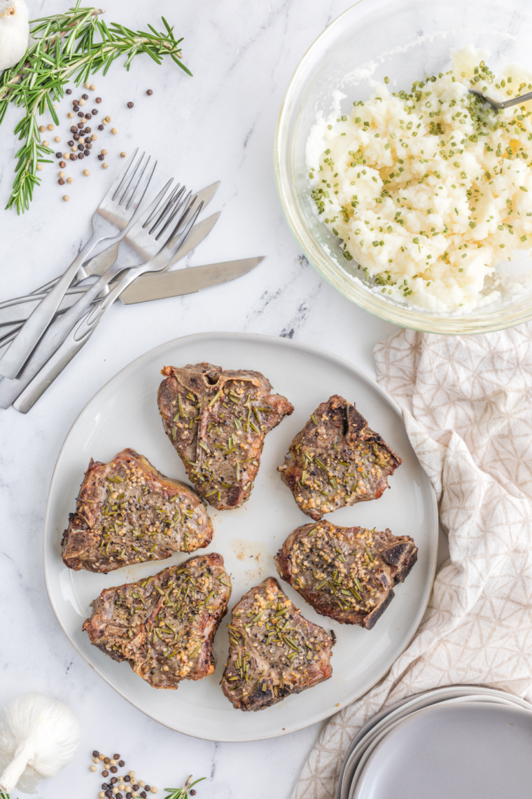 Air fryer frozen lamb chops served with a rosemary garnish, ready to eat