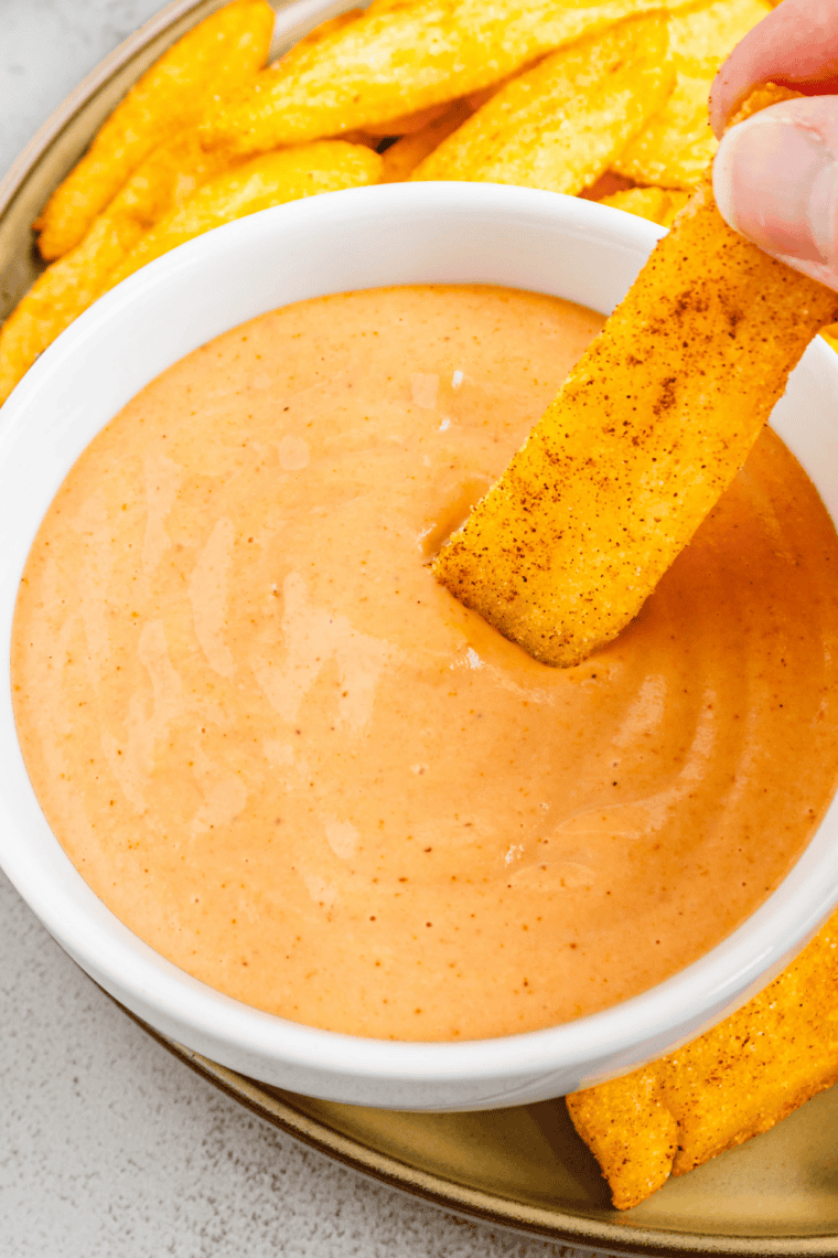 Crispy Red Robin steak fry being dipped into creamy campfire sauce