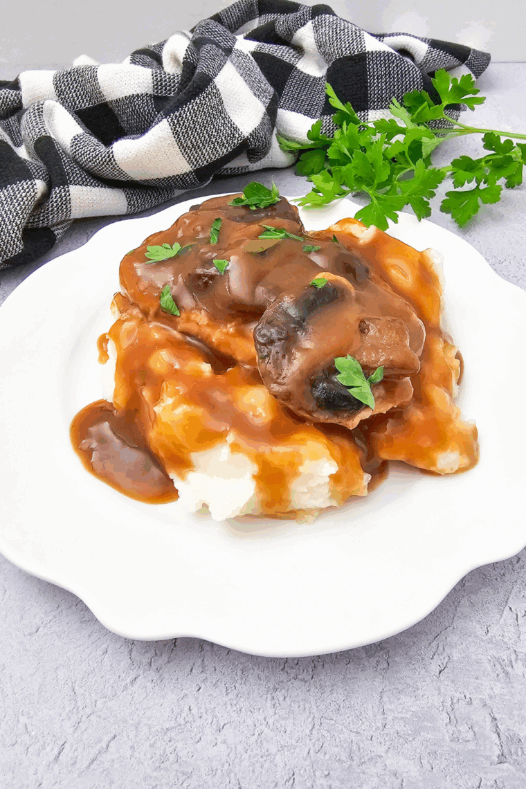 Slow cooker filled with juicy, seasoned pork chops cooking in rich savory sauce.