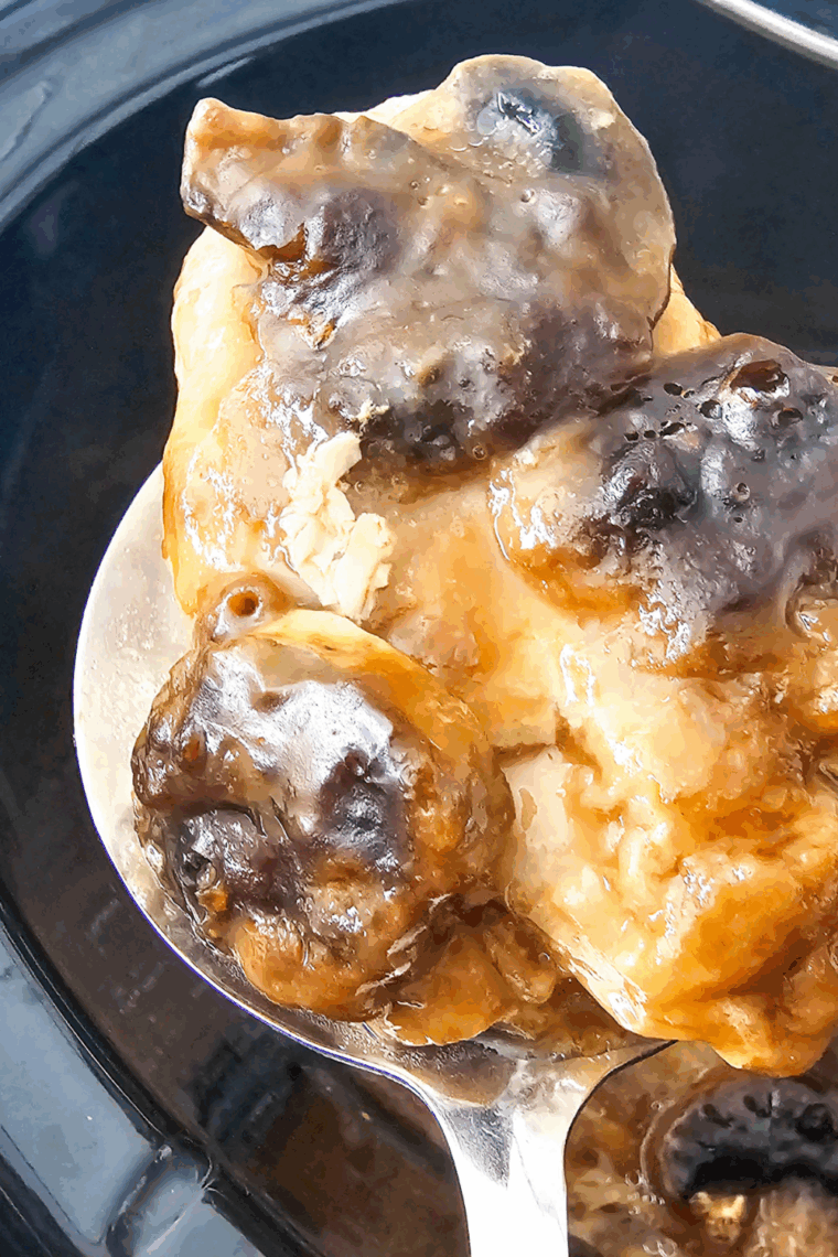 Slow cooker with boneless pork chops, mushrooms, and brown gravy cooking to tender perfection.