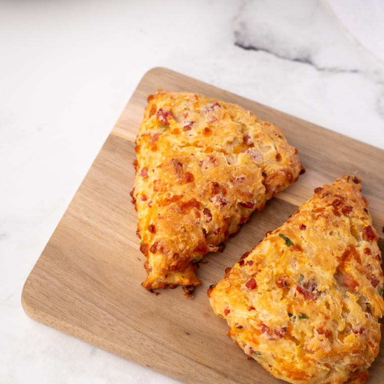 Air fryer cheese scone split open and spread with butter