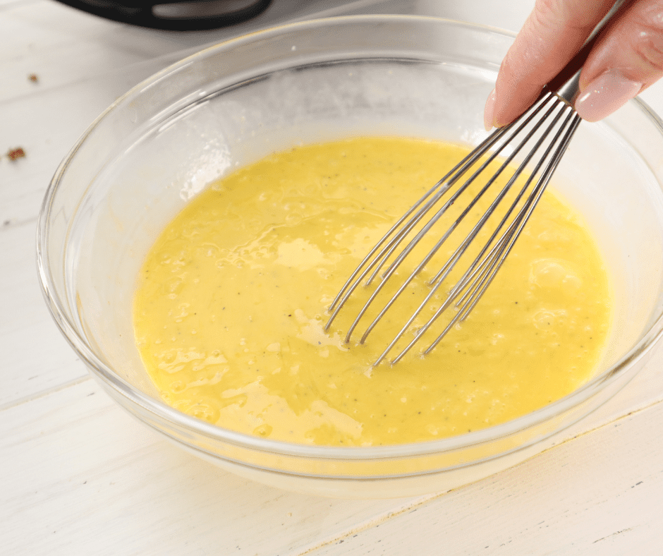 Cracking eggs into a bowl and whisking them to prepare the filling for the breakfast burritos.