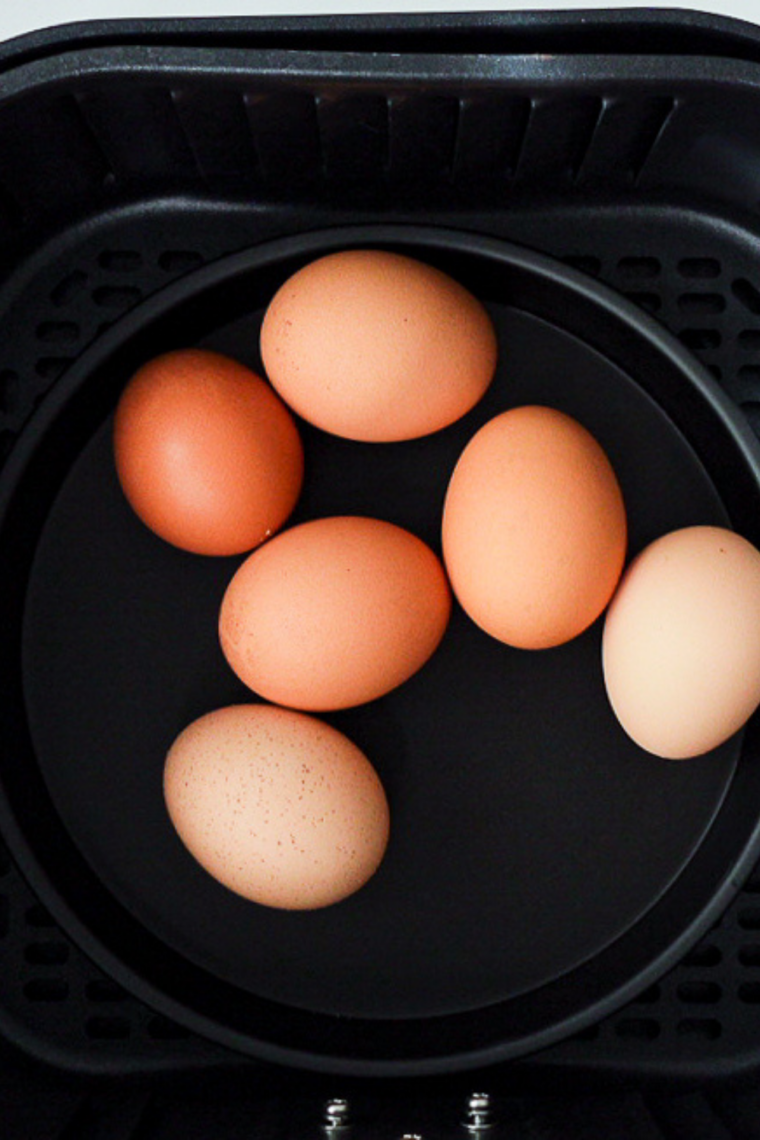 Preheating air fryer to 270–275°F for gently cooking eggs evenly from shell to yolk