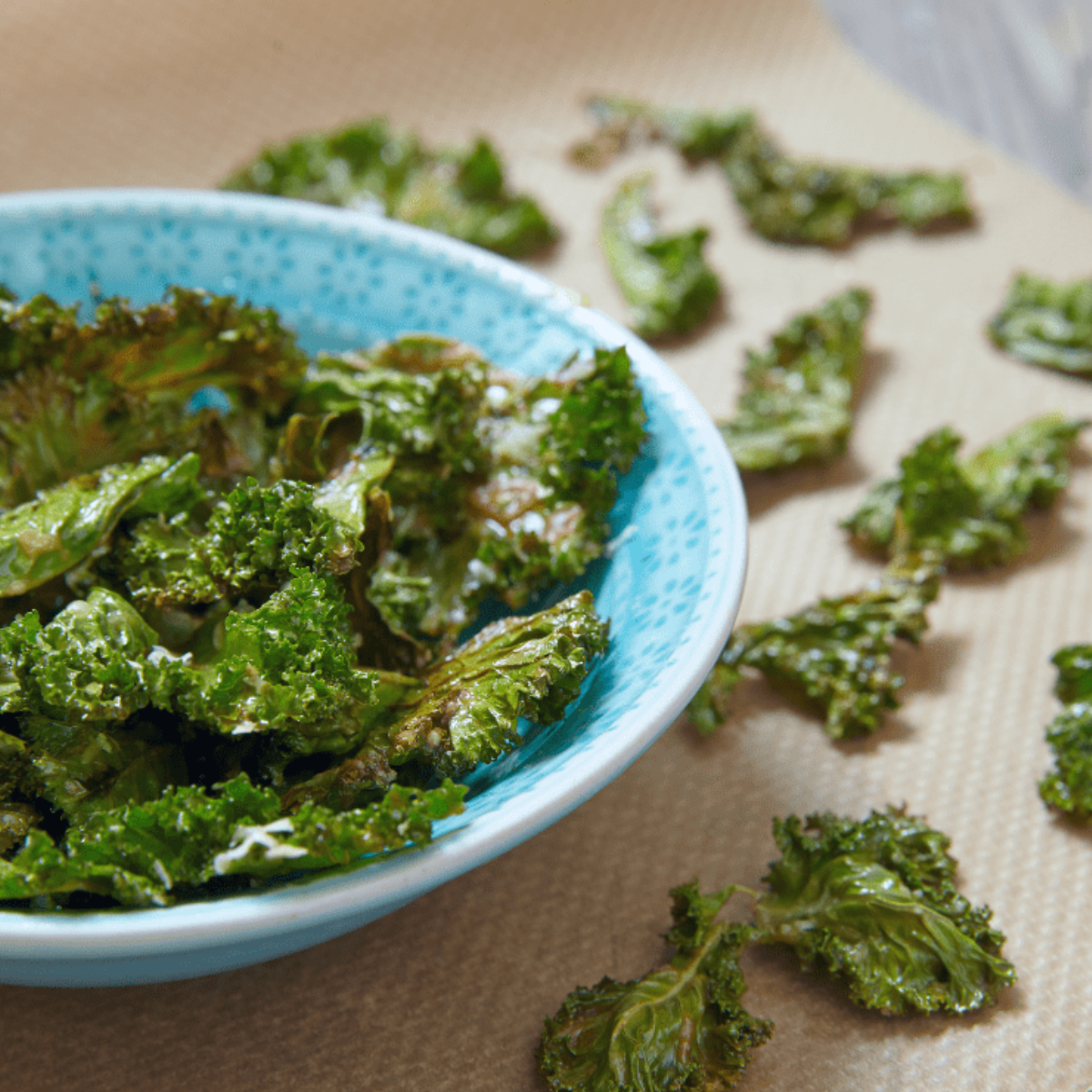 Plate of crispy Air Fryer Kale Chips made without oil, showcasing vibrant green kale seasoned and cooked to perfection.
