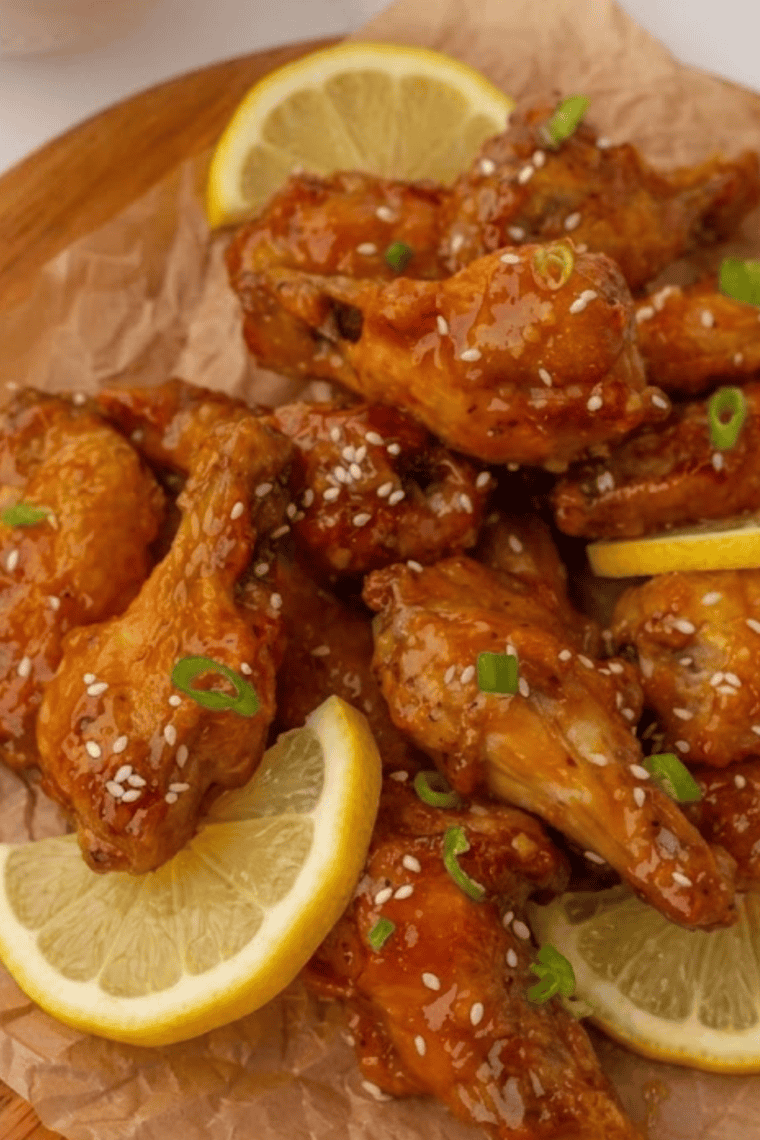 Close-up of golden naked wings tossed in lemon pepper seasoning