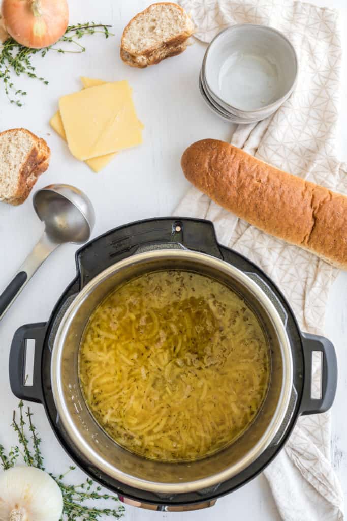 Adding beef broth to the Instant Pot for French Onion Soup after caramelizing the onions."