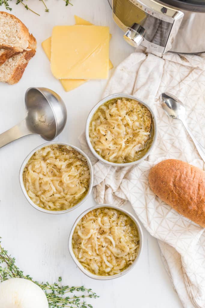 "Layering slices of French bread and cheese on top of the French Onion Soup in the Instant Pot."