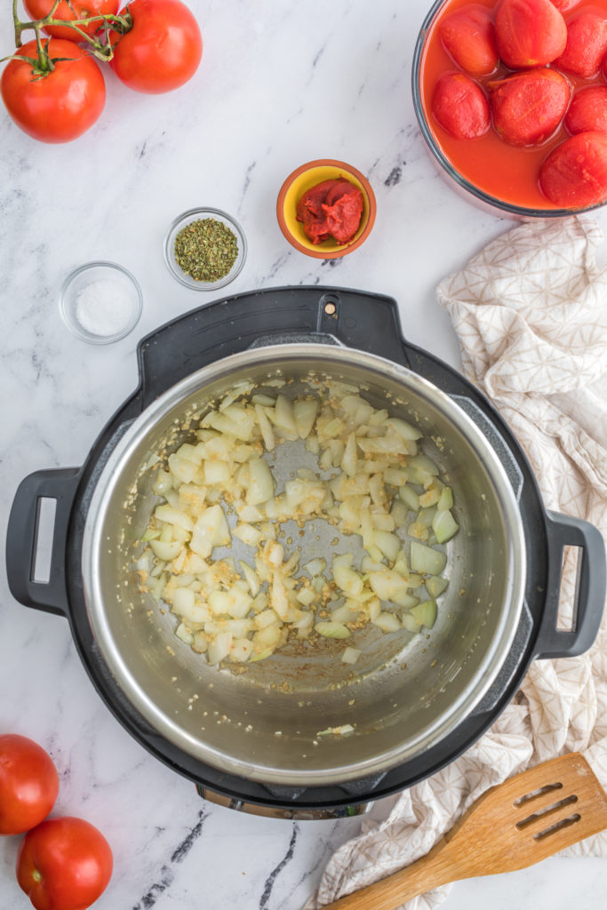 "Adding diced tomatoes and vegetables to the Instant Pot for the Panera creamy tomato soup."