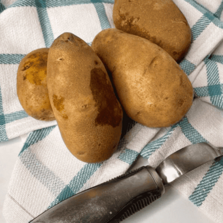 Peeled russet potatoes cut into 1-inch cubes on a cutting board
