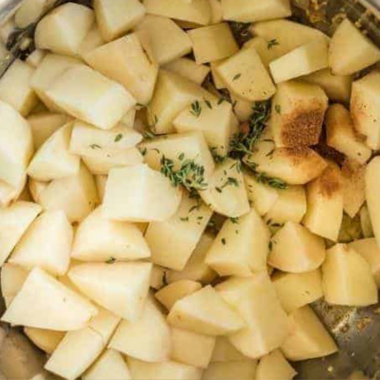 Diced potatoes simmering in a pot of water on the stovetop