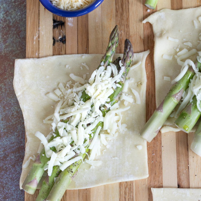 Arrange asparagus spears diagonally on each pastry piece and sprinkle with mozzarella cheese.
