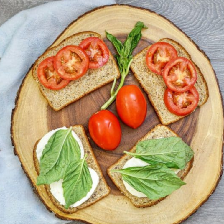 Assembling the sandwiches on cutting board.
