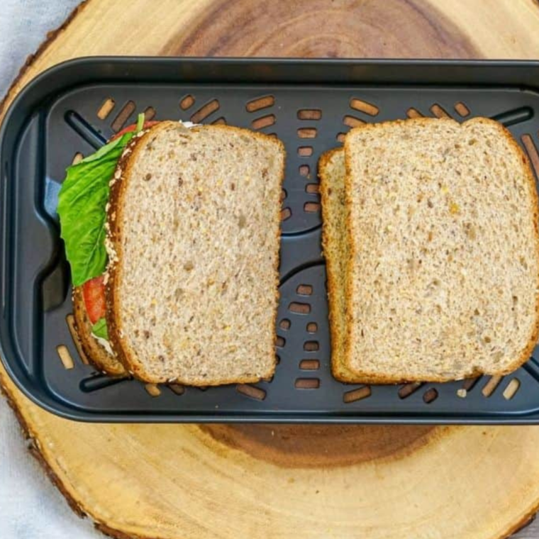 Assembled sandwiches on air fryer tray or air fryer basket, ready to be cooked.