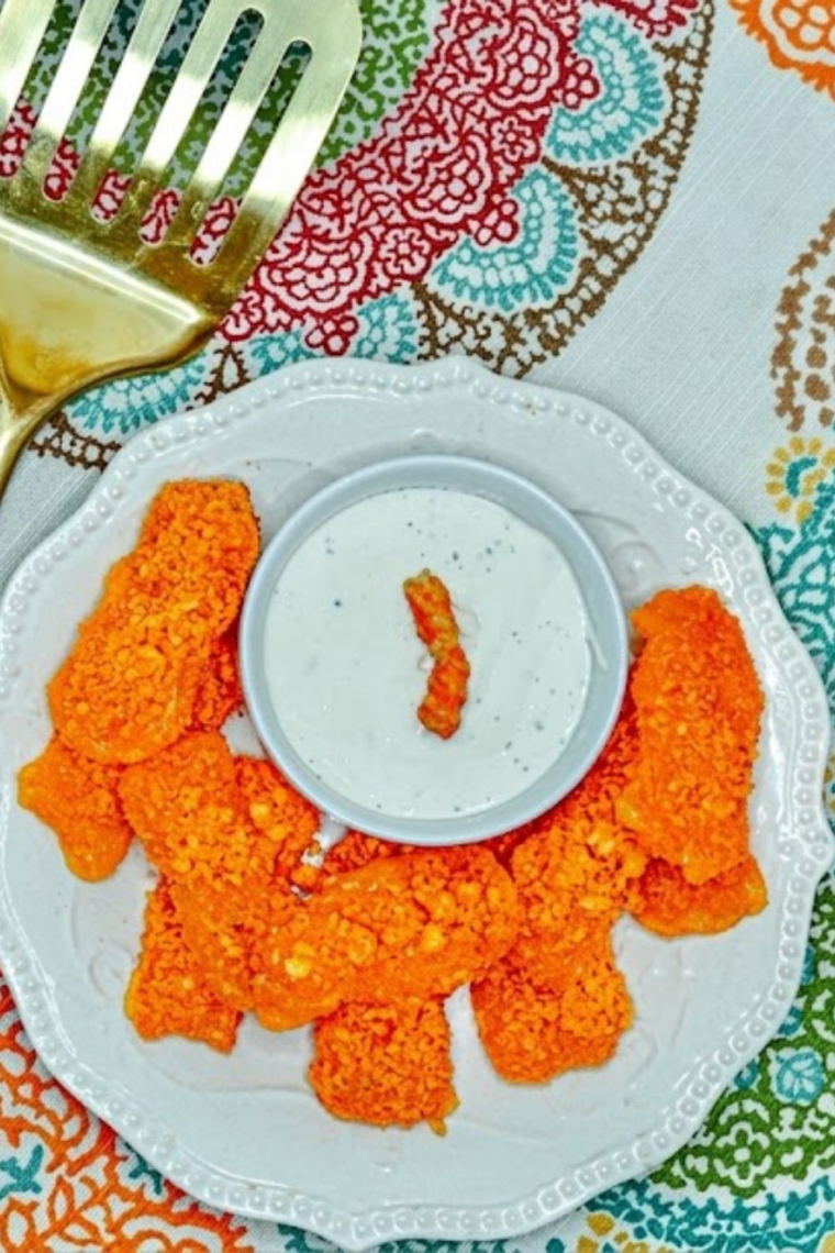 Air fryer mozzarella sticks coated in crushed Cheetos golden crispy exterior with melted cheese pull snack appetizer.