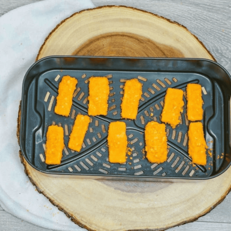 Air fryer basket with Cheetos-coated mozzarella sticks cooking at 390°F until golden, crispy, and lightly oozing melted cheese.