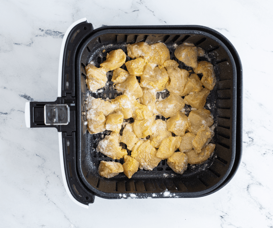 Breaded chicken minis arranged in a single layer in the air fryer basket