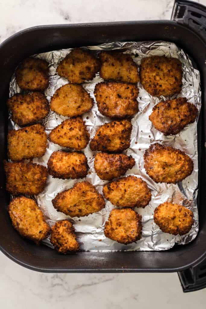 "Coating chicken with flour and seasoning before air frying"